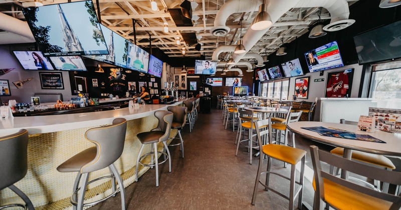 Interior, tables and chairs, tv screens on the wall