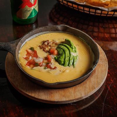 Creamy cheese dip topped with pico de gallo, shredded pork and sliced avocado