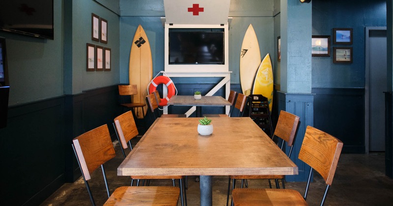 Interior, table and chairs with surf boards in the back