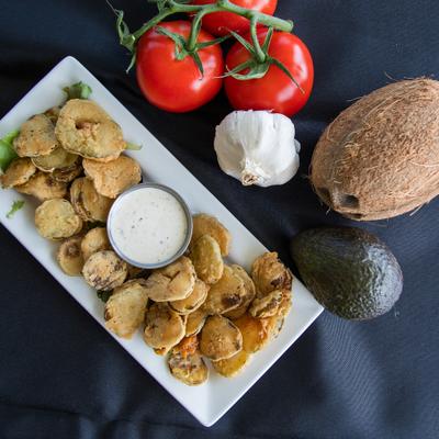Fried Pickles served with a dipping sauce, alongside fresh fruit and veggies.