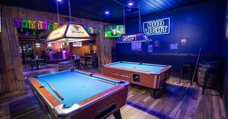 Interior, dining area in the back, billiards tables, neon signs, barrel table in the corner