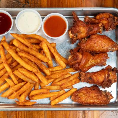Chicken wings, fries, and dipping sauces.