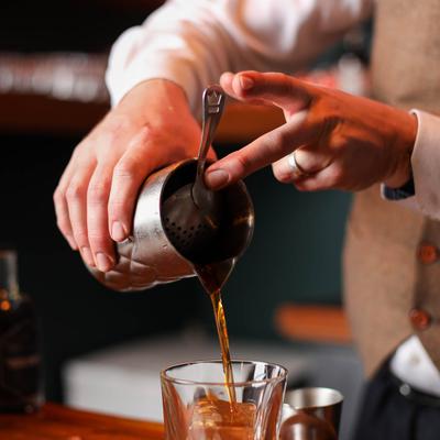 Bartender pouring a cocktail.