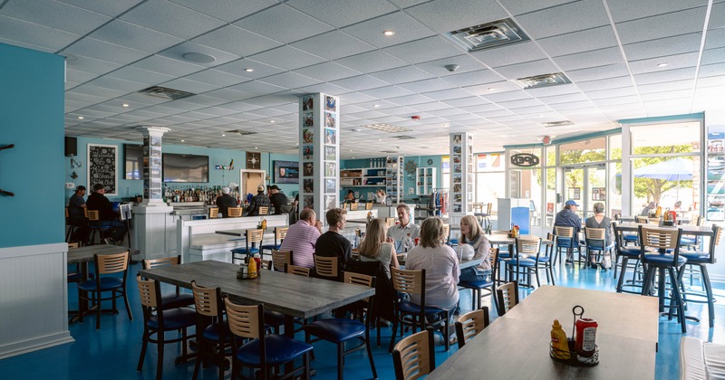 Spacious restaurant dining area with blue floors and seated guests