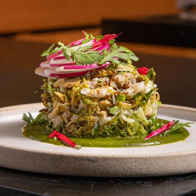 Dungeness Crab Salpicon garnished with thinly sliced radishes and fresh herbs.