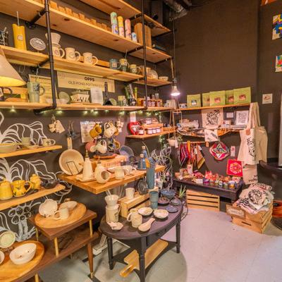 Coffee shop interior with shelves, merchandise, and warm lighting.