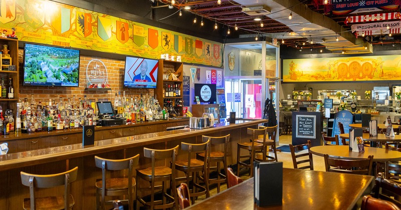 Interior, tables and stools with bar on the left