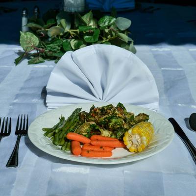 Vegetable plate with carrots, brussel sprouts, asparagus and corn on the cob.