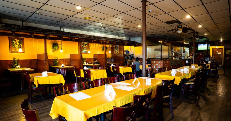 Dining room with yellow tables and dark wooden chairs