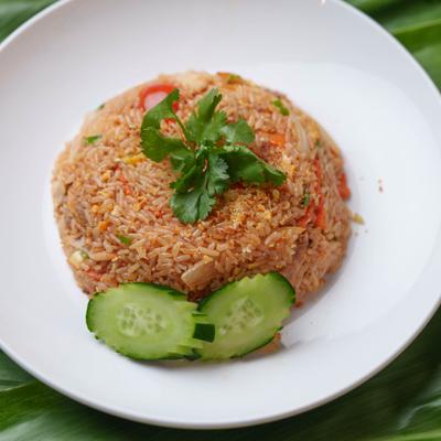 Thai fried rice garnisged with two slices of cucamber and fresh herbs.