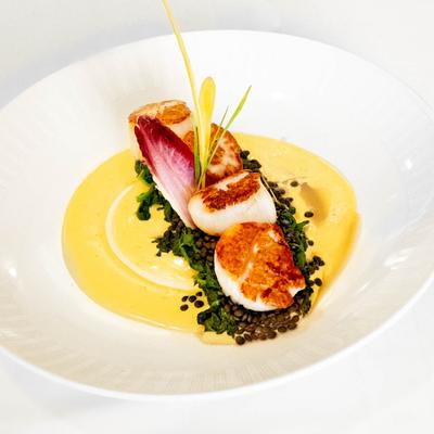 Pan seared scallops, with Champagne sauce, saffron, spinach, and lentils.