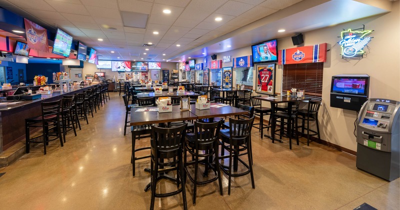 Interior, tables with bar stools, a bar on the left