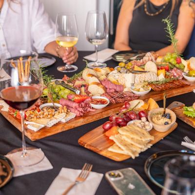 Charcuterie board and wine glasses served to a group of guests.
