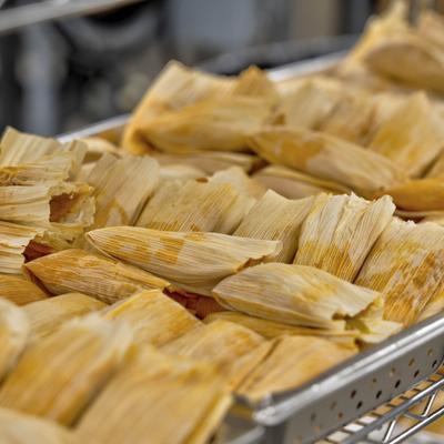 Tamales stacked on a tray.