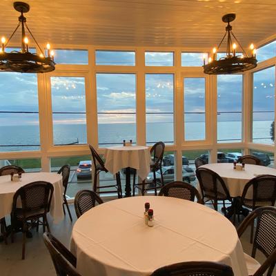 Restaurant interior, tables and chairs offering a scenic view of the lake.