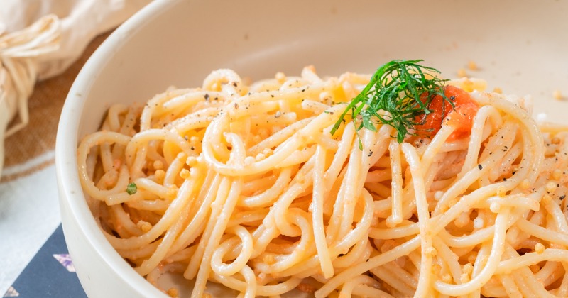 Mentaiko spaghetti garnished with herbs in a white dish