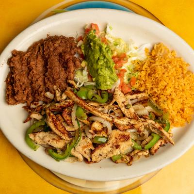 Chicken fajitas served with refried beans, rice, guacamole, shredded lettuce with tomatoes.