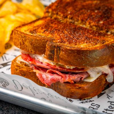 Reuben sandwich with chips on the side, close-up.