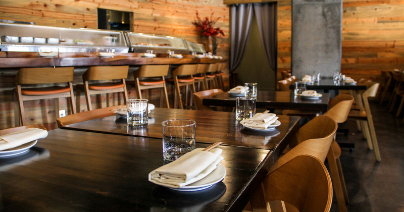 Interior, closeup of lined up tables with tableware, and glasses