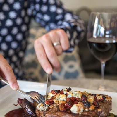 Enjoying steak with cheese dish and red wine.