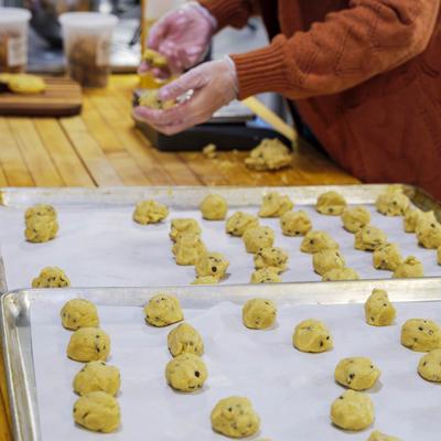 Chocolate chip cookie dough balls on trays with baking paper.