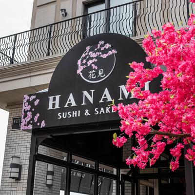 Hanami Sushi and Sake restaurant exterior with cherry blossom decor and black sign.