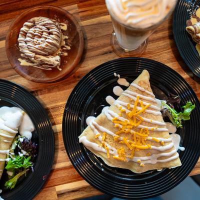 Assorted crepe plates and a milkshake, top view.