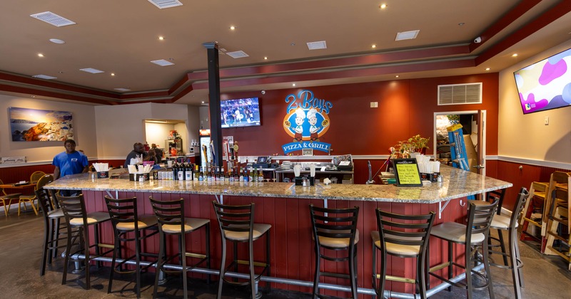 A cozy bar with a curved granite counter, high chairs