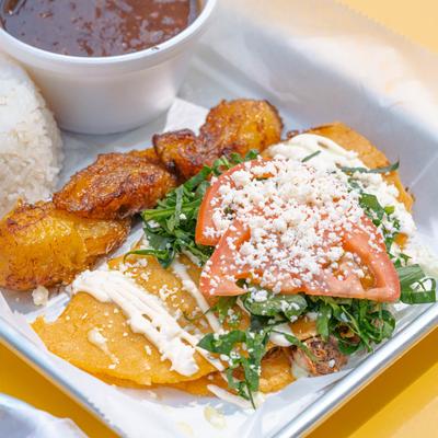 Tortilla with shredded beef, cheese, tomato, plantains, rice, and beans.