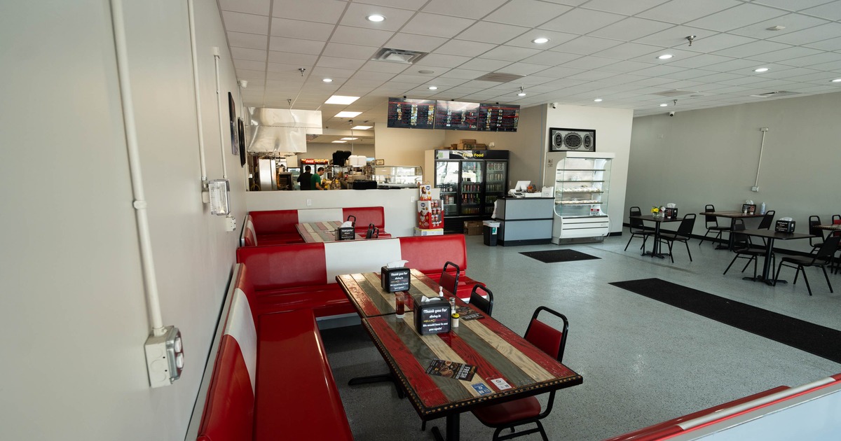 Interior, seating area, bar and open kitchen in the back, checkout counter