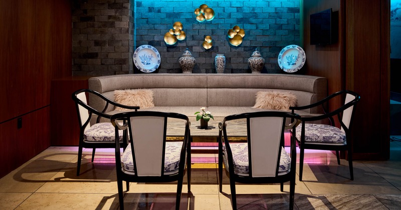 Interior, seating area with a gray sofa, decorative vases, cushioned chairs, coffee table