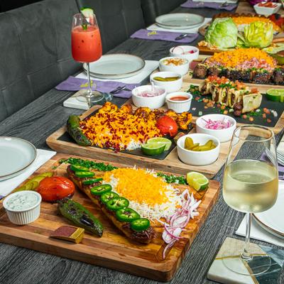 Assortment of food dishes and drinks served on a table with place settings.