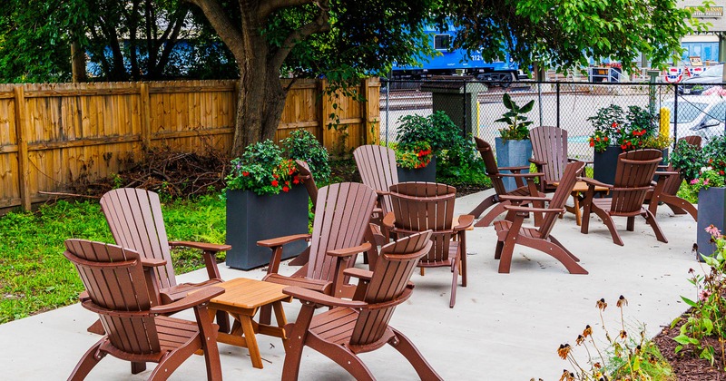Exterior, backyard, seating area, wooden armchairs with coffee tables for four