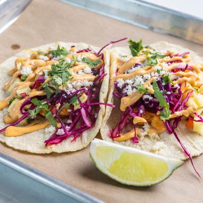 Grilled shrimp tacos topped with cabbage and creamy sauce.