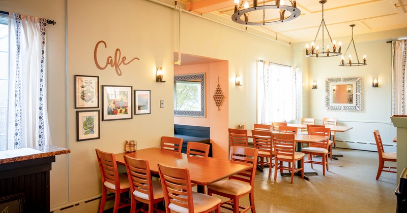 Interior, dining area, wooden top tables for six, framed paintings, carpet flooring