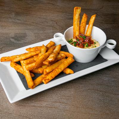 Fried naan bread sticks served with a creamy dip topped with herbs and sun-dried tomatoes.