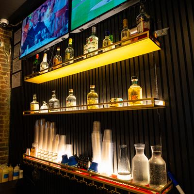 Multi-tiered backlit shelving units with liquor bottles arranged on them.