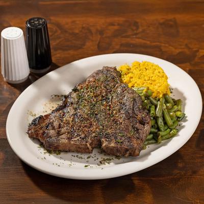 Sirloin steak served with yellow rice and green beans.
