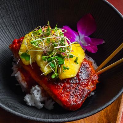 Hawaiian BBQ Salmon, served over sushi rice with pineapple and micro greens.