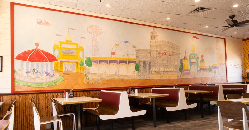 Mural - amusement park scene inside a restaurant; booths and tables in the background