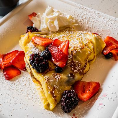 Crepe with creme fraiche, seasonal berries, chocolate drizzle, and whipped cream.