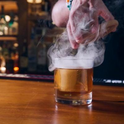 Old Fashioned cocktail being smoked.