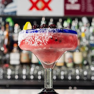 Blackberry margarita served on a bar counter.