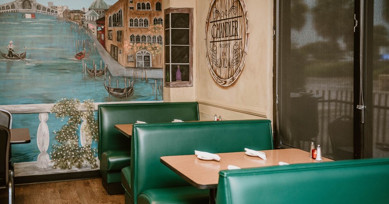 Restaurant interior with Venetian mural and green booths.