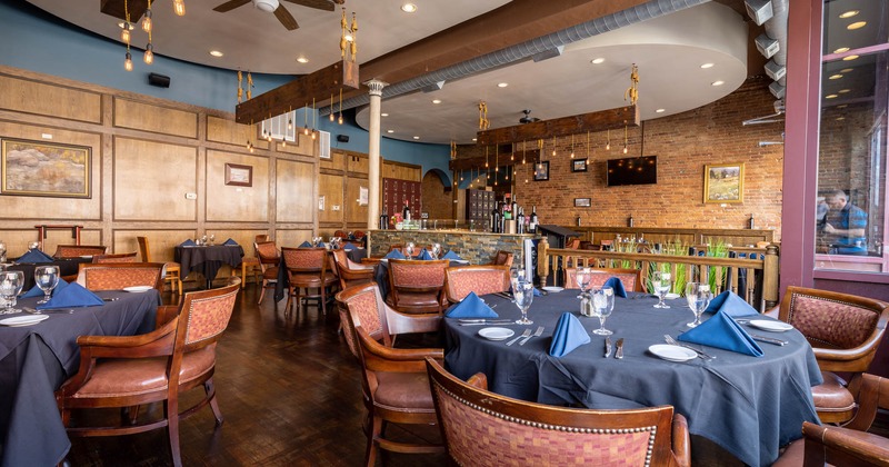 Inside, round tables set and ready to receive guests, a bar