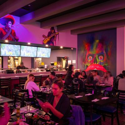 Restaurant dining area with colorful wall art.