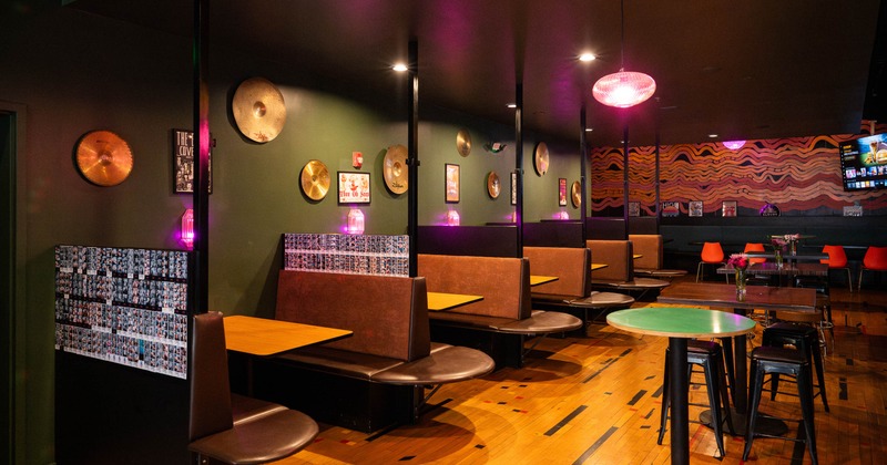 Interior seating area with booth seating, cymbals on green walls and vibrant decor