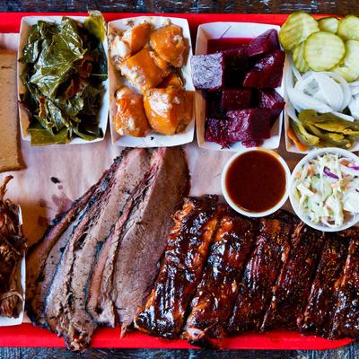 BBQ Platter, pulled pork, brisket, and ribs with side dishes.