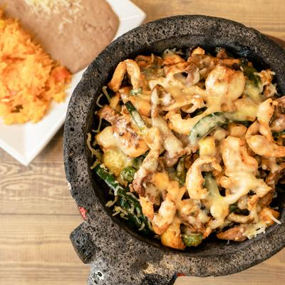 Molcajete dish with sides of rice and beans.