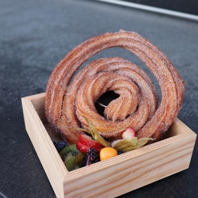 Churro spiral dusted with cinnamon sugar and served with fruits.